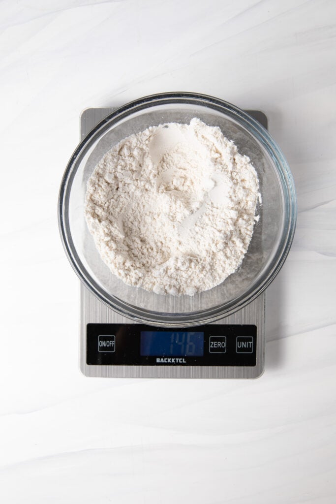 Add gluten free flour in a bowl on a scale.