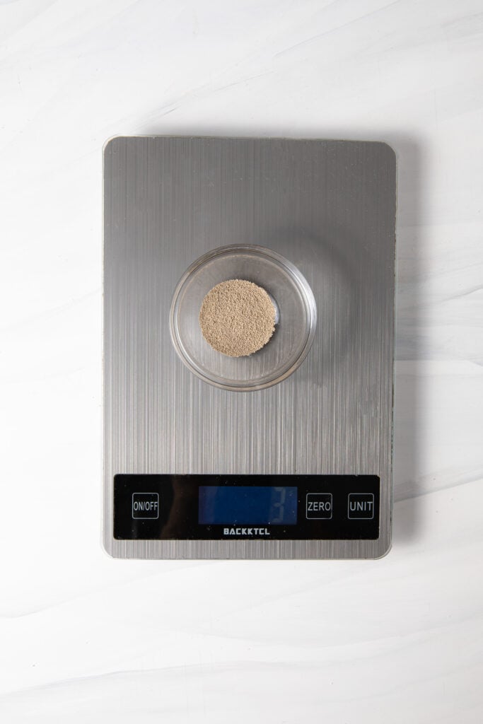 Add yeast in a bowl on a scale.