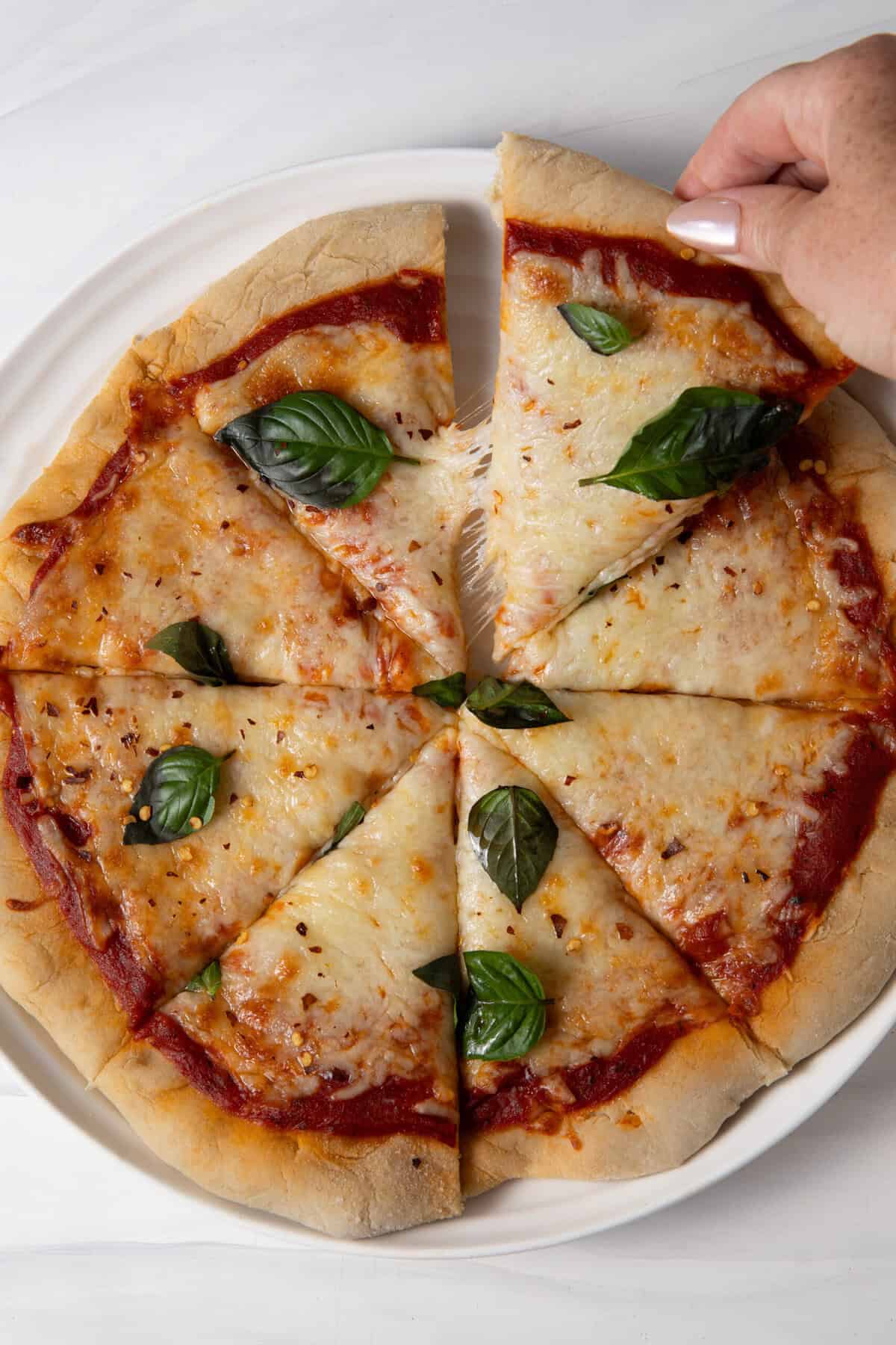 Taking a slice out of the Gluten Free Sourdough Discard Pizza Crust for Sourdough Pizza.