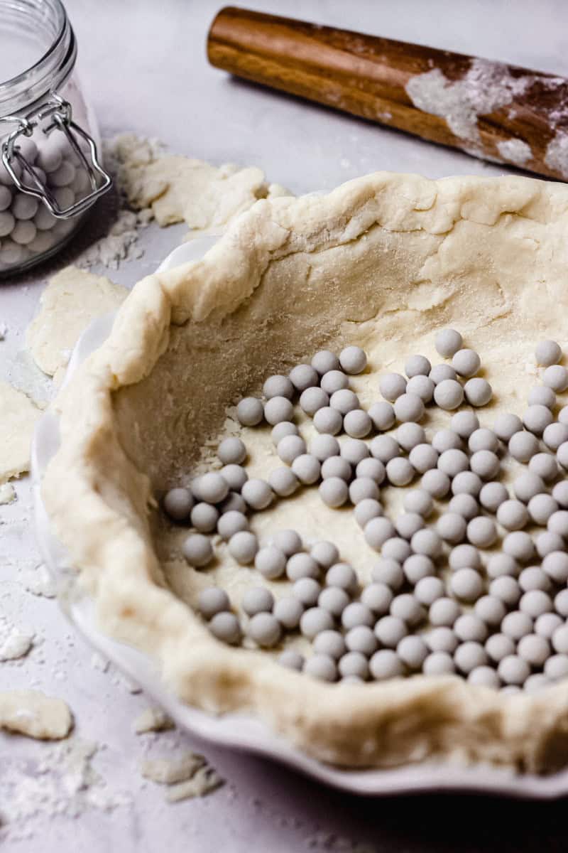 gluten free pie crust in a pie pan with pie weights