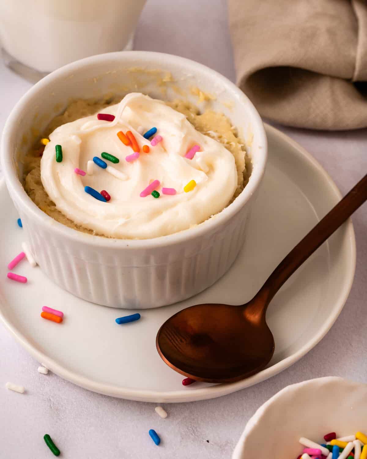 funfetti mug cake with frosting and sprinkles