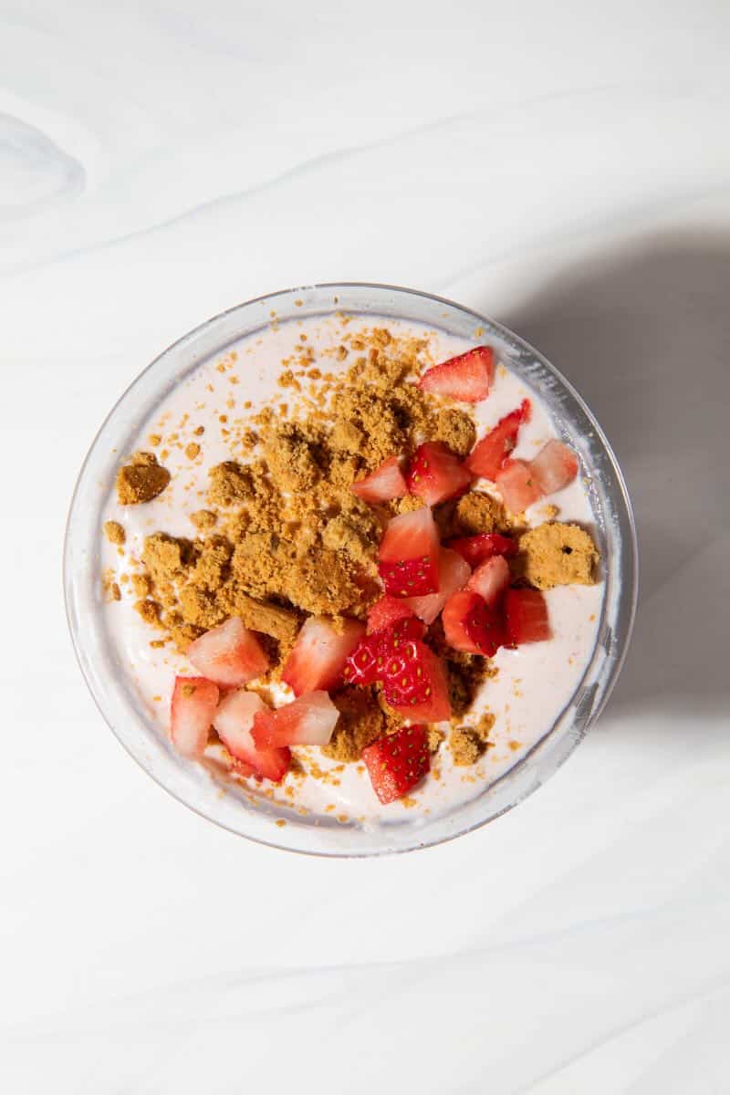 strawberry cheesecake ninja creami ice cream in a pint container with toppings