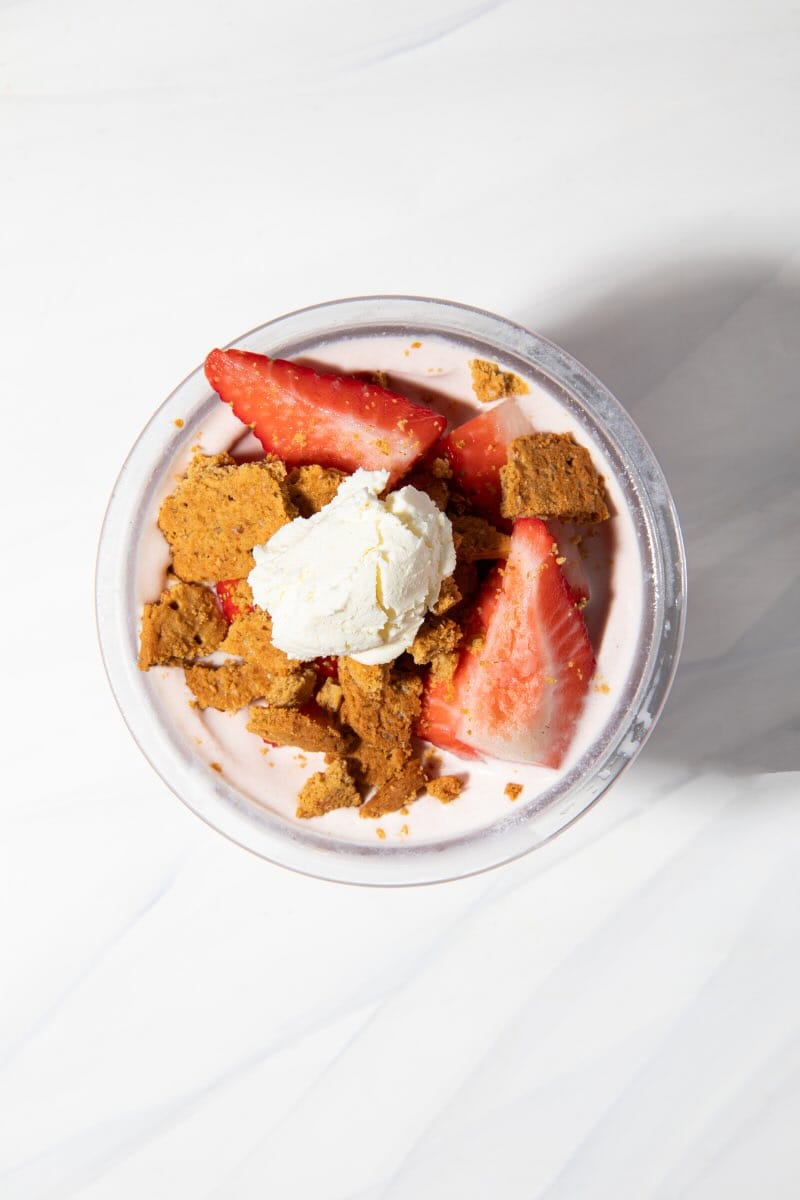 strawberry cheesecake ninja creami in a pint container with mix ins