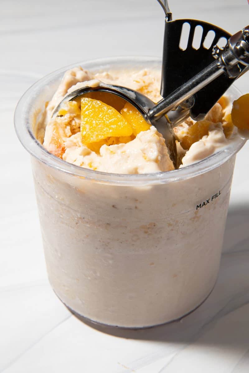 scooping peach ninja creami ice cream from the container