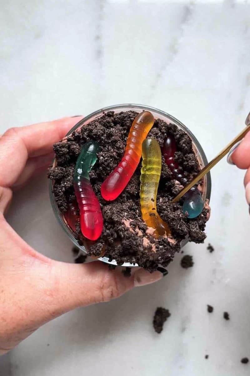 taking a bite out of a dirt cup with gummy worms