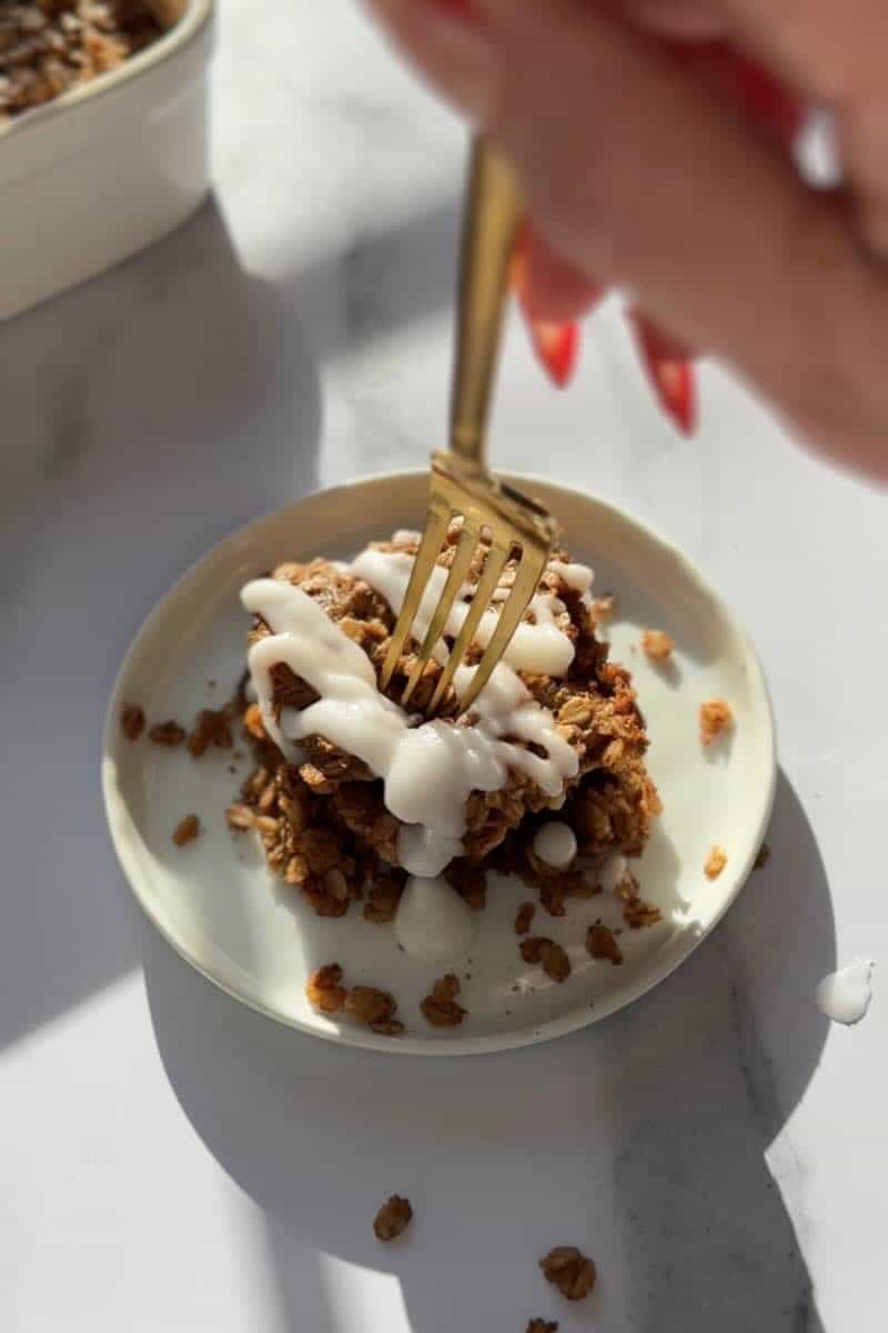 fork piercing into slice of cinnamon roll baked oatmeal
