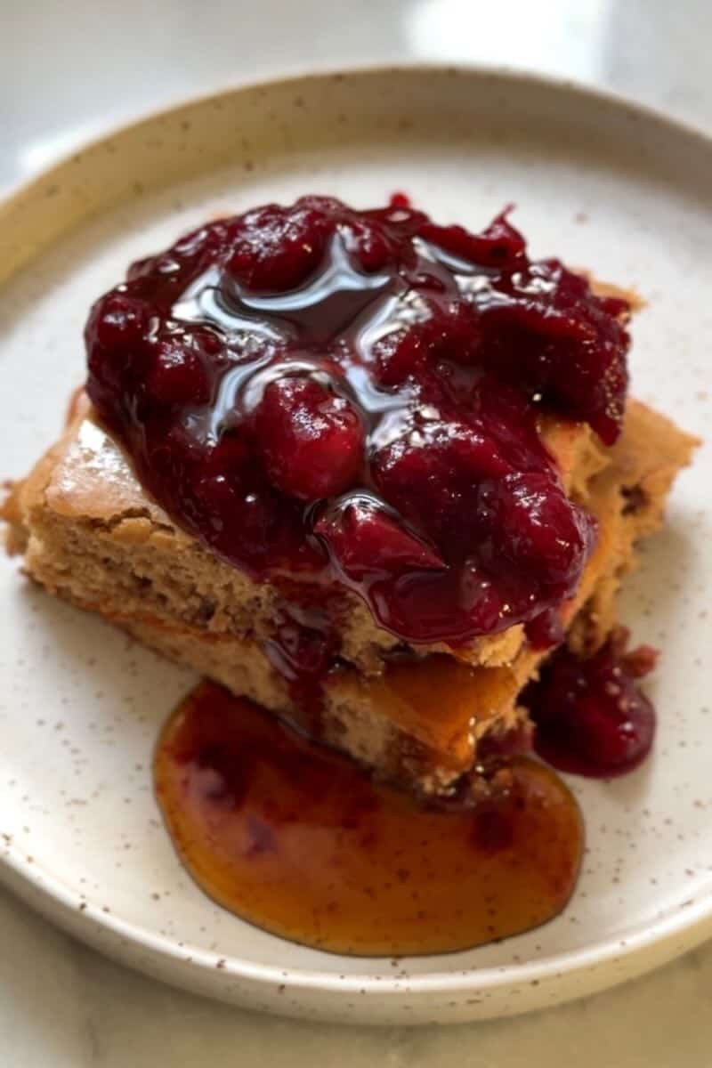 sheet pan pancakes on a plate with fruit and syrup
