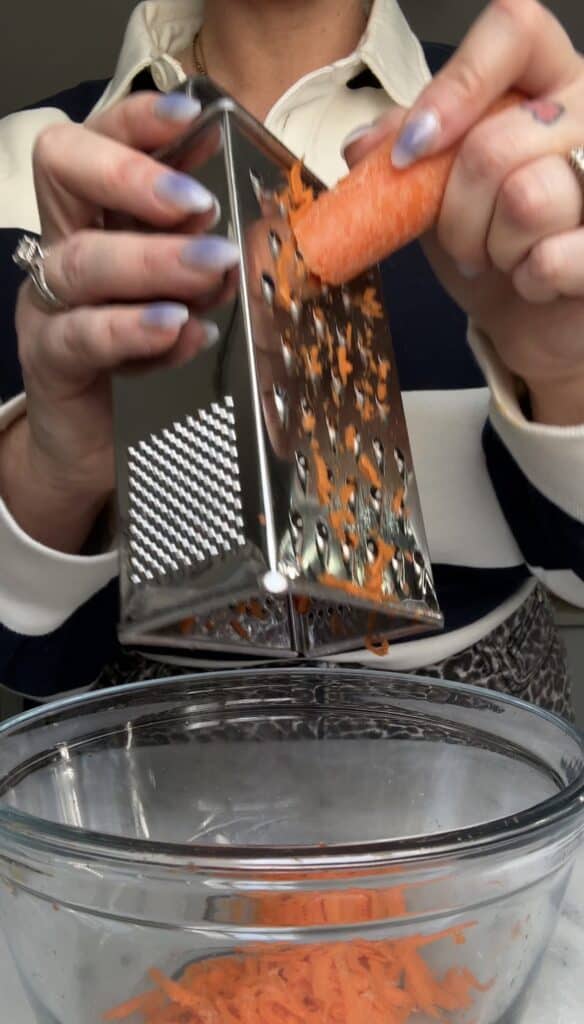 Grate your 2-3 carrots into a bowl by hand.