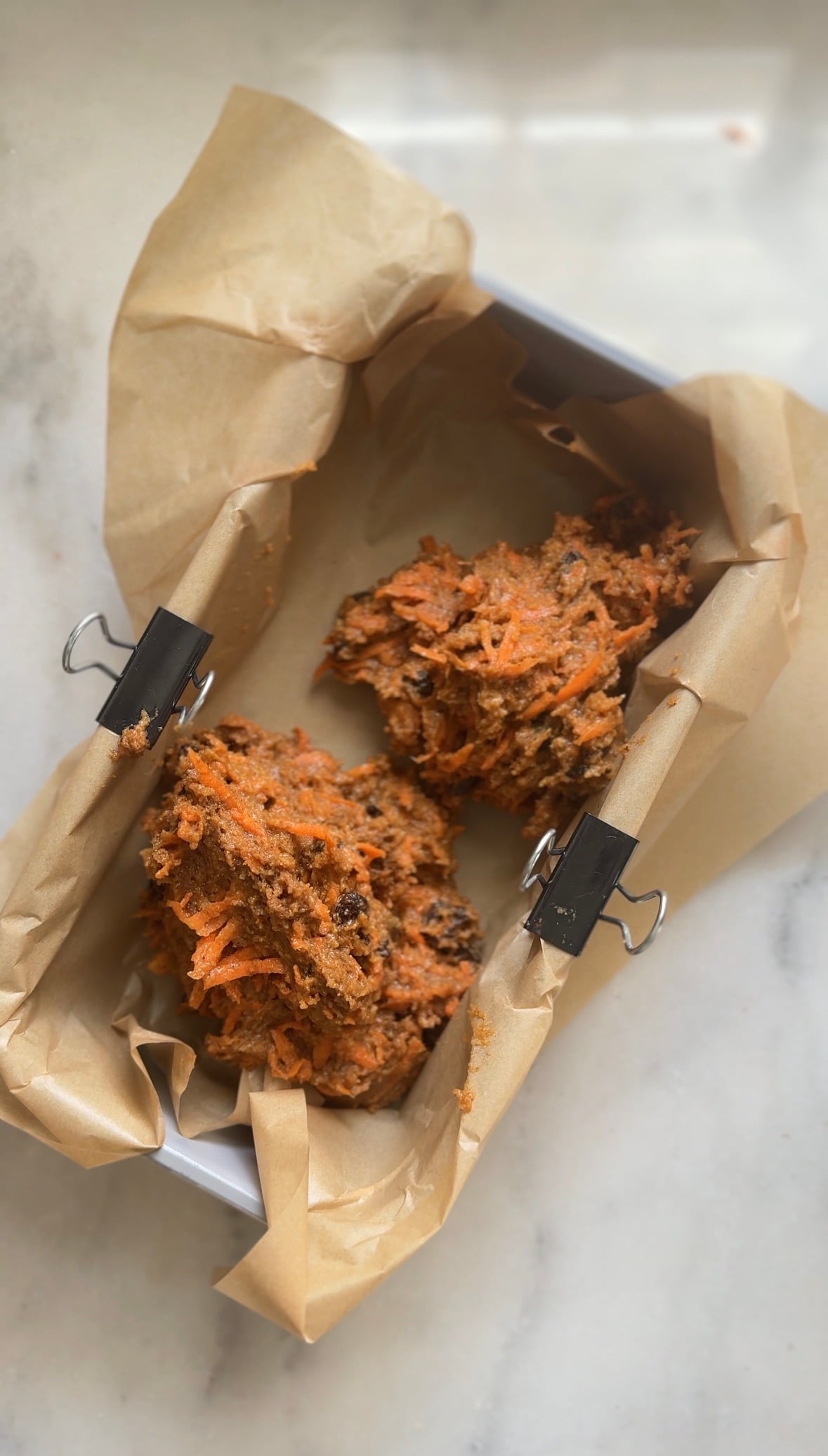 Pour the high protein carrot cake batter into a parchment lined loaf pan.