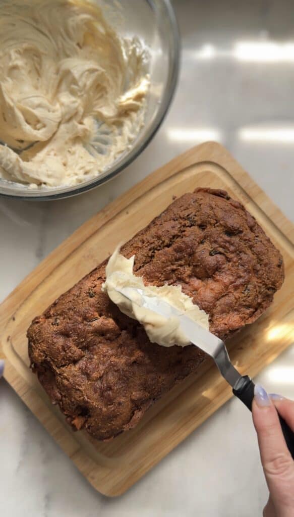 Spread the cream cheese frosting onto the cooled high protein carrot cake.