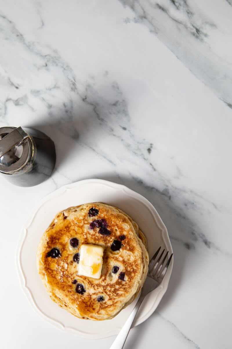 Top view of finished gluten free blueberry oatmeal protein pancakes on a plate.