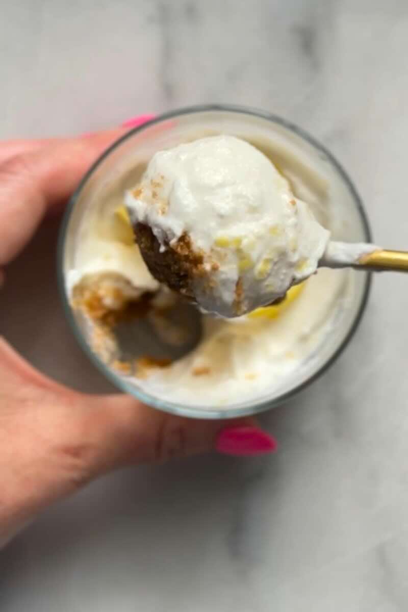 A spoonful of the No Bake Lemon Cottage Cheese Cheesecake Cup to show texture of the crust and cheesecake filling.