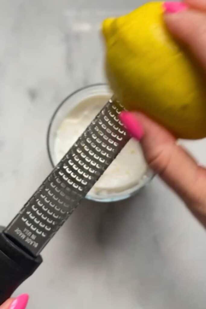 Zest a fresh lemon over the cheesecake filling of the No Bake Lemon Cottage Cheese Cheesecake Cups on top of the graham cracker crust in the cup.