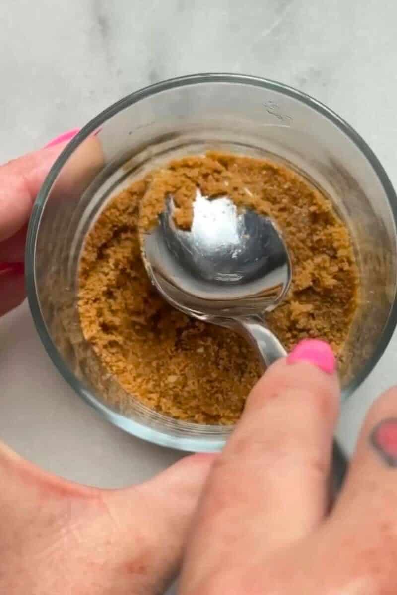 Press the graham cracker crust of the No Bake Lemon Cottage Cheese Cheesecake Cups into a small cup or ramekin.