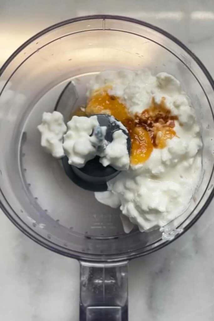 Pour the ingredients into the food processor to make the cheesecake filling of the No Bake Lemon Cottage Cheese Cheesecake Cups on top of the graham cracker crust in the cup.