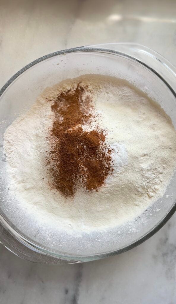 Add the cinnamon on top of the rest of the dry ingredients of the blueberry cottage cheese protein muffins into a bowl.