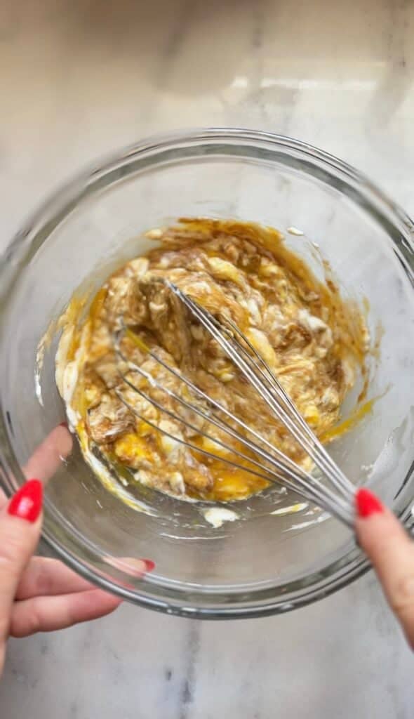 Mix the wet ingredients of the blueberry cottage cheese protein muffins in a bowl with a whisk.