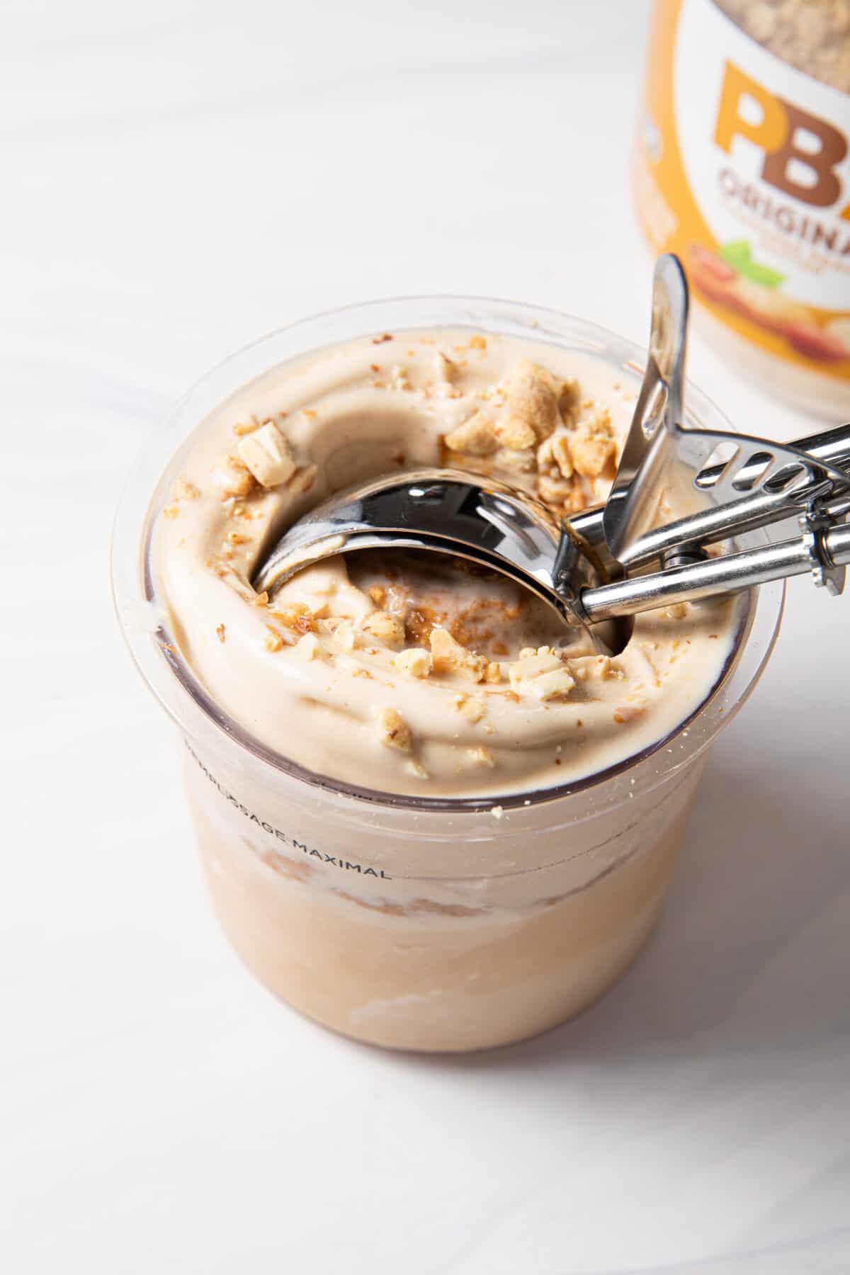 Finished peanut butter Ninja Creami with pb fit protein powder being scooped with an ice cream scoop.