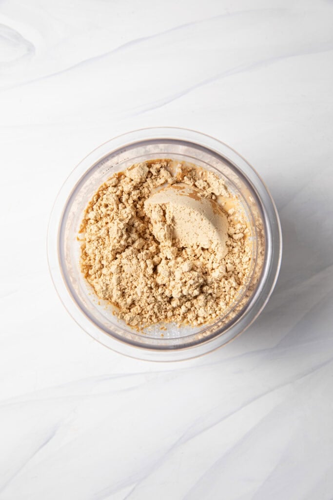 Making the peanut butter protein ice cream base starting with both milks, dates, and PB Fit in the Ninja Creami pint jar.