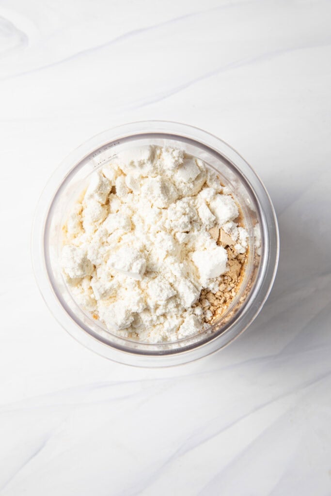 Making the peanut butter protein ice cream base starting with both milks, dates, PB Fit, and protein powder in the Ninja Creami pint jar.
