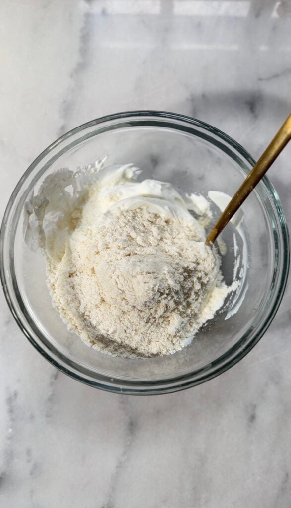 Protein-packed yogurt and protein powder for the easy protein banana pudding in a bowl.