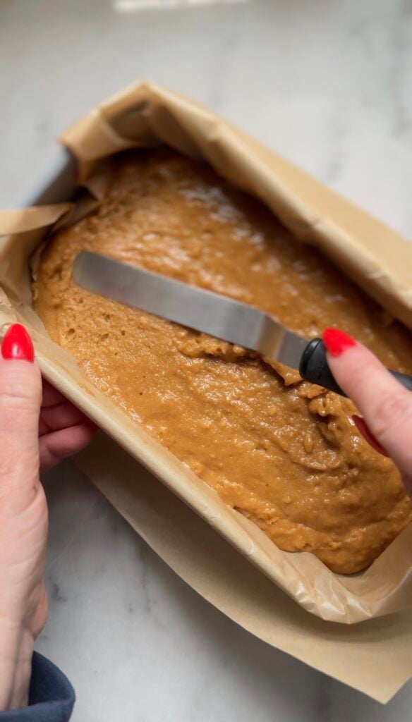Level the protein lemon cake batter in the prepared cake loaf pan lined with parchment paper.