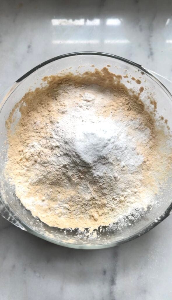All the dry ingredients for the protein lemon cake before being mixed together by whisk in a bowl.