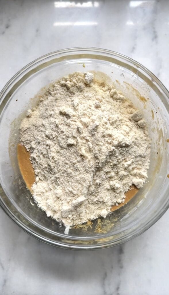 Combining the wet and dry ingredients for the protein lemon cake together in a bowl.
