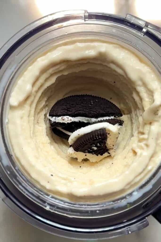 Put Oreos in the frozen base of the Ninja Creami Protein Dairy Free Oreo Cookies and Cream Ice Cream in the ninja creami pint to be blended.