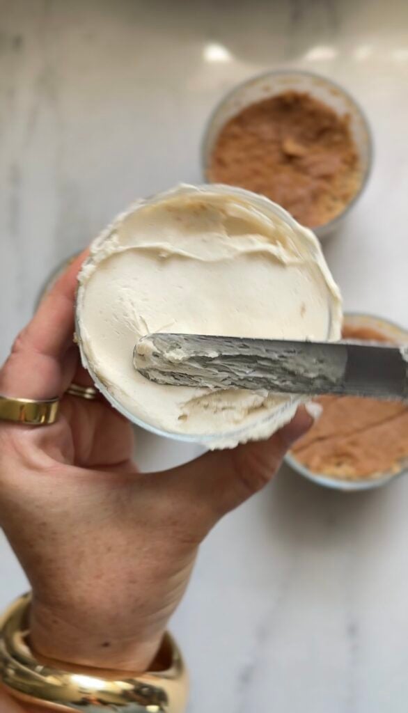 Frosting the dot cake with an icing spatula to have an even flat layer of frosting on top.