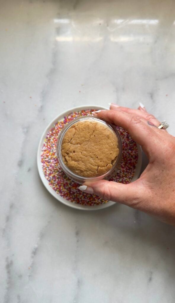 Push the flat frosting layer into the sprinkles until the whole top is evenly coated with sprinkles.