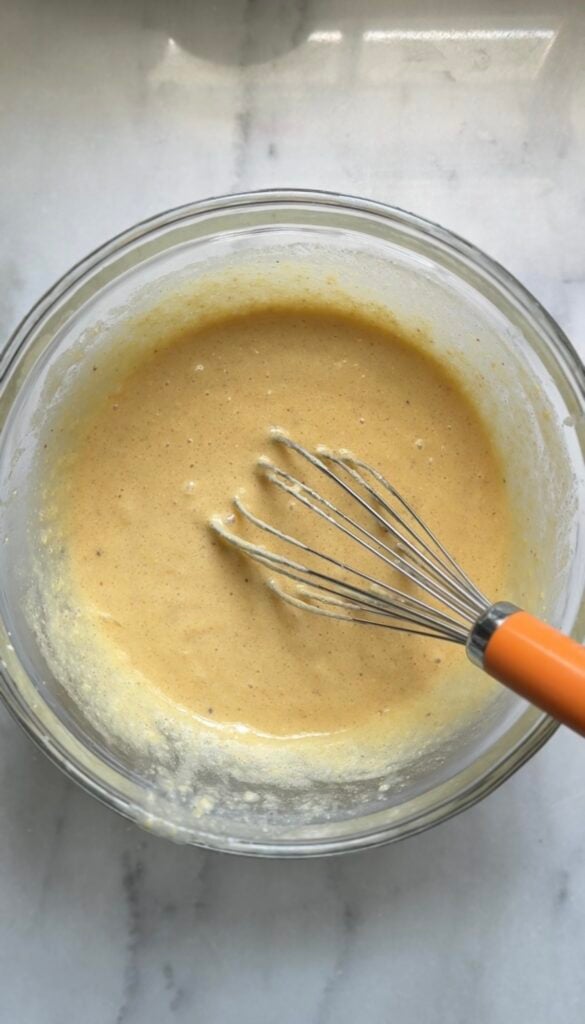 Mix the dairy free and gluten free viral dot cake recipe a bowl with a whisk.
