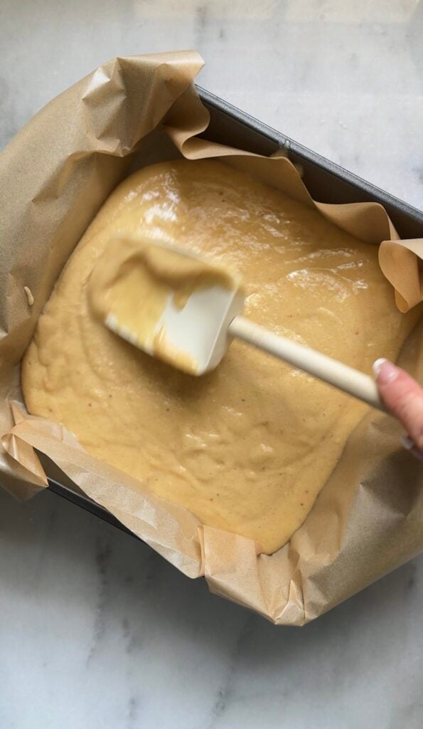 Level the dairy free and gluten free viral dot cake recipe in the 8x8 cake pan lined with parchment paper.