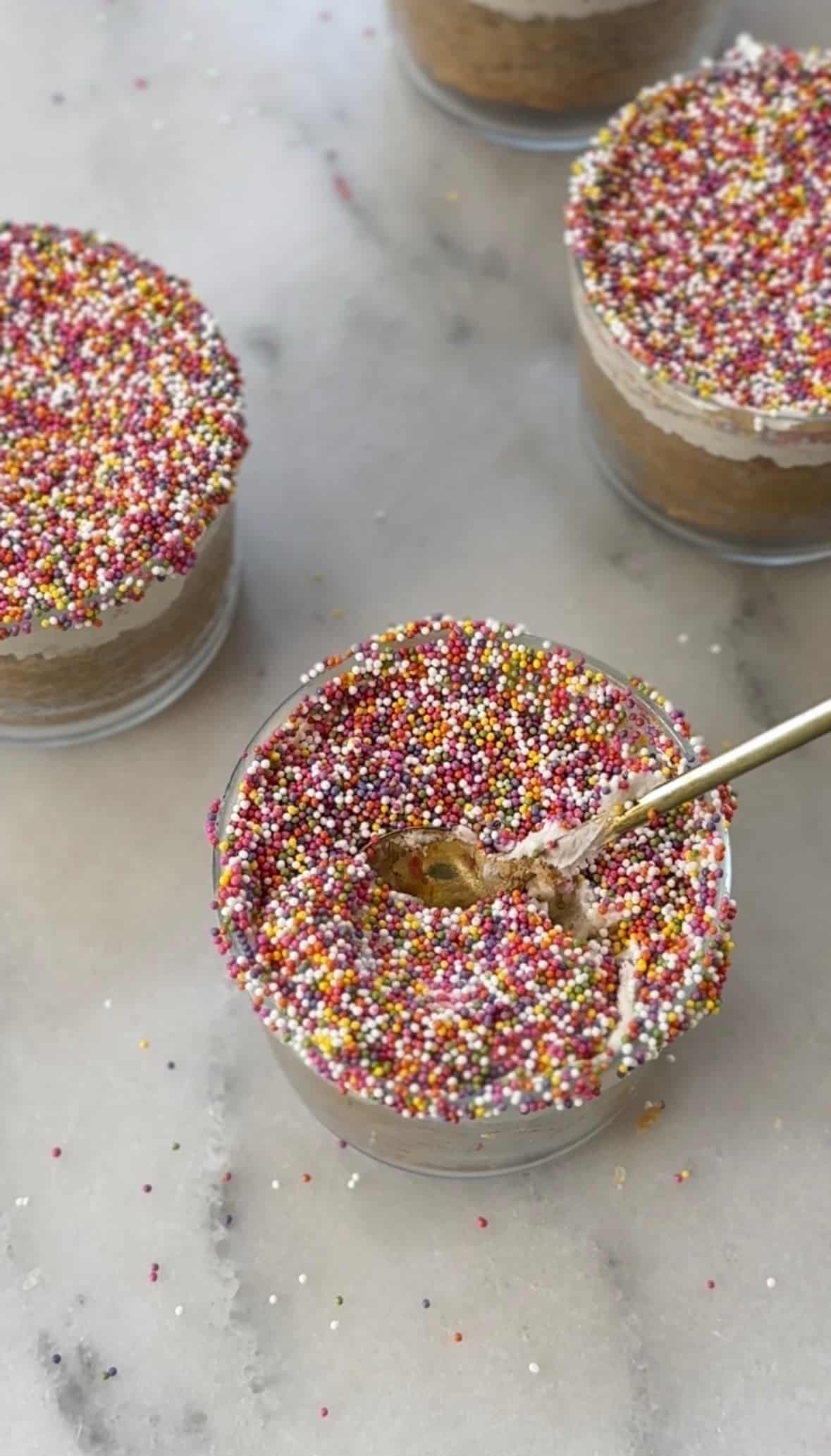 The dairy free and gluten free version of the viral dot cake recipe in a glass with a spoon ready to eat.