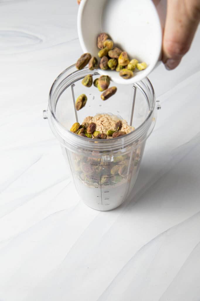 Pour pistachios into the blender bottle.