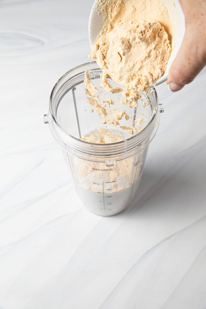Pour vanilla protein powder into the blender bottle.