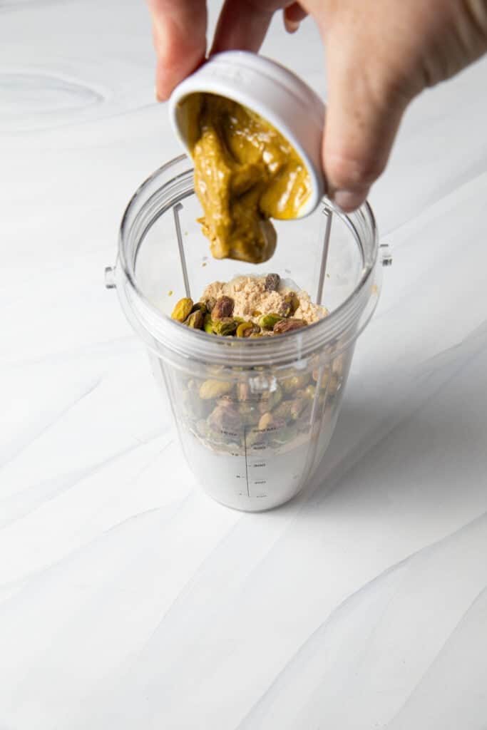 Pour pistachio butter into the blender bottle.