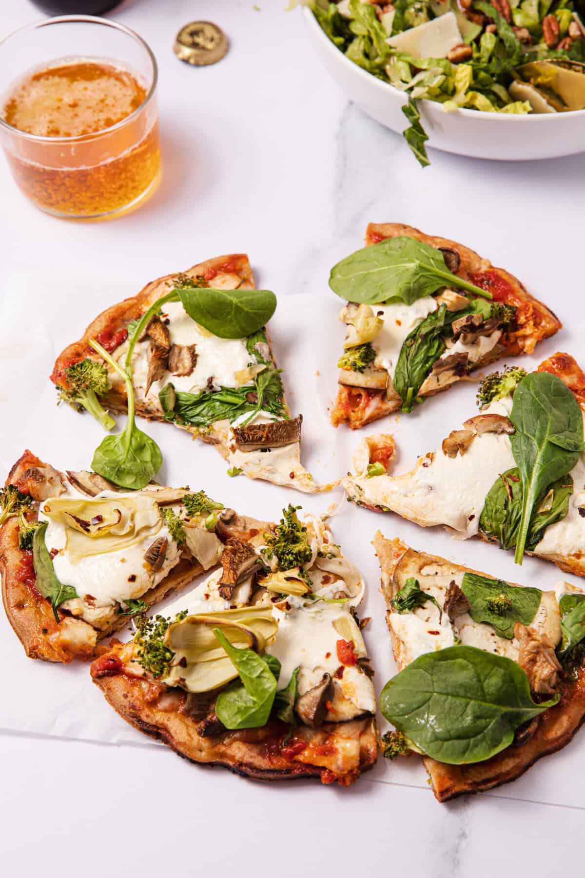 Roasted veggie pizza slices served with a salad.