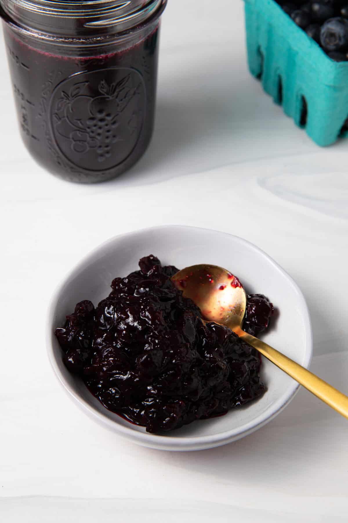 Fresh Blueberry Simple Syrup compote in a bowl with a spoon.