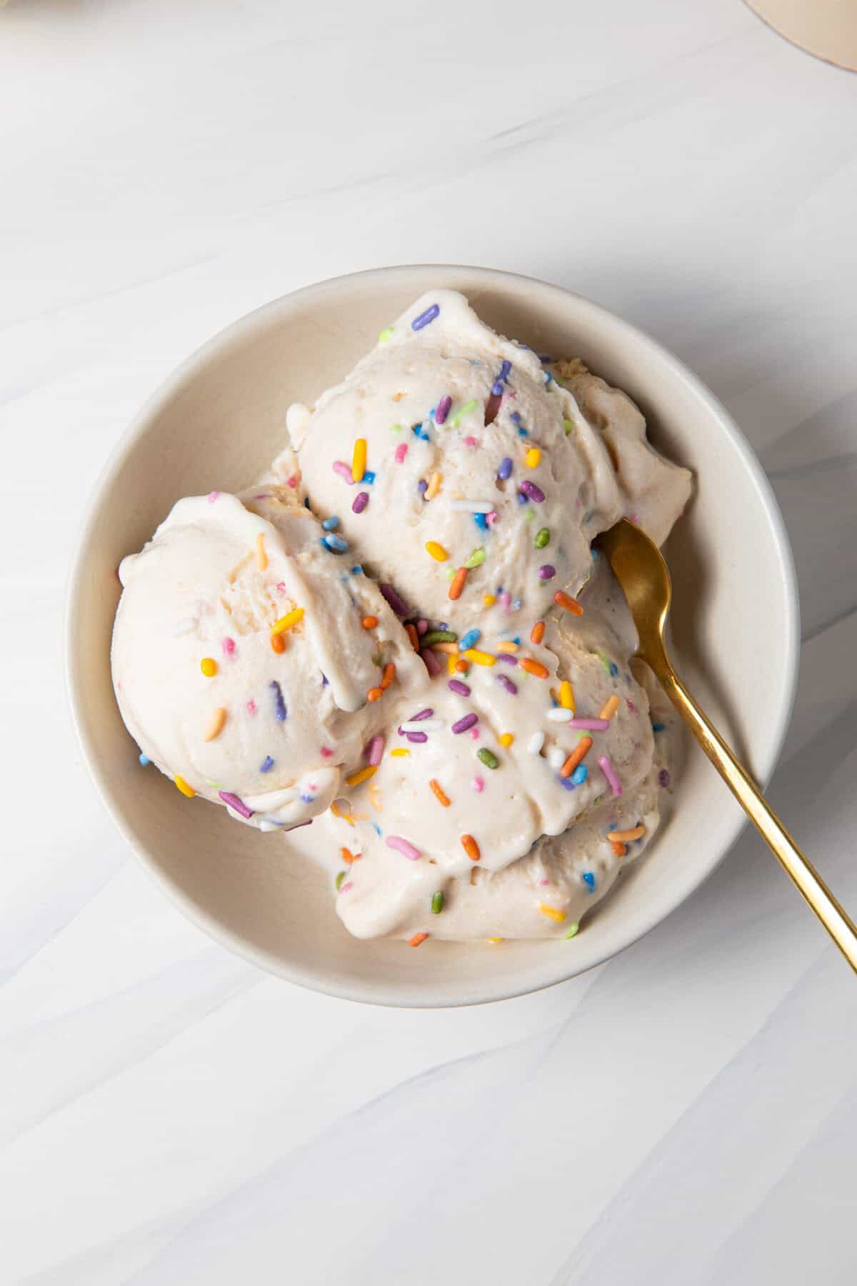 Birthday Cake Batter Protein Ninja Creami Ice Cream in a bowl with a spoon.