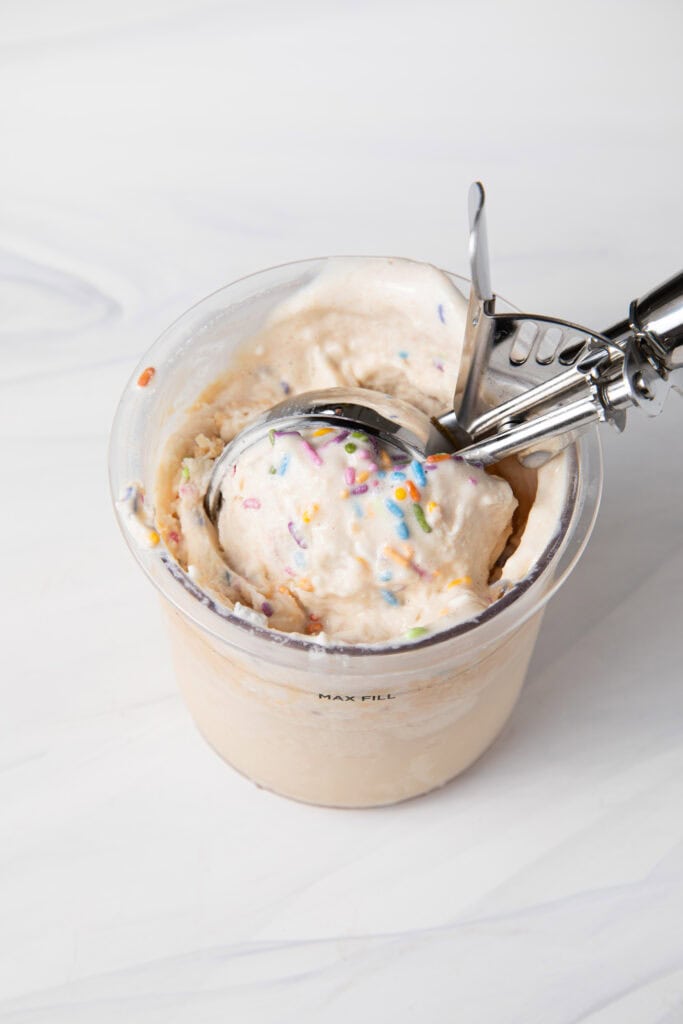 Birthday Cake Batter Protein Ninja Creami Ice Cream base in the Ninja Creami pint being scooped.
