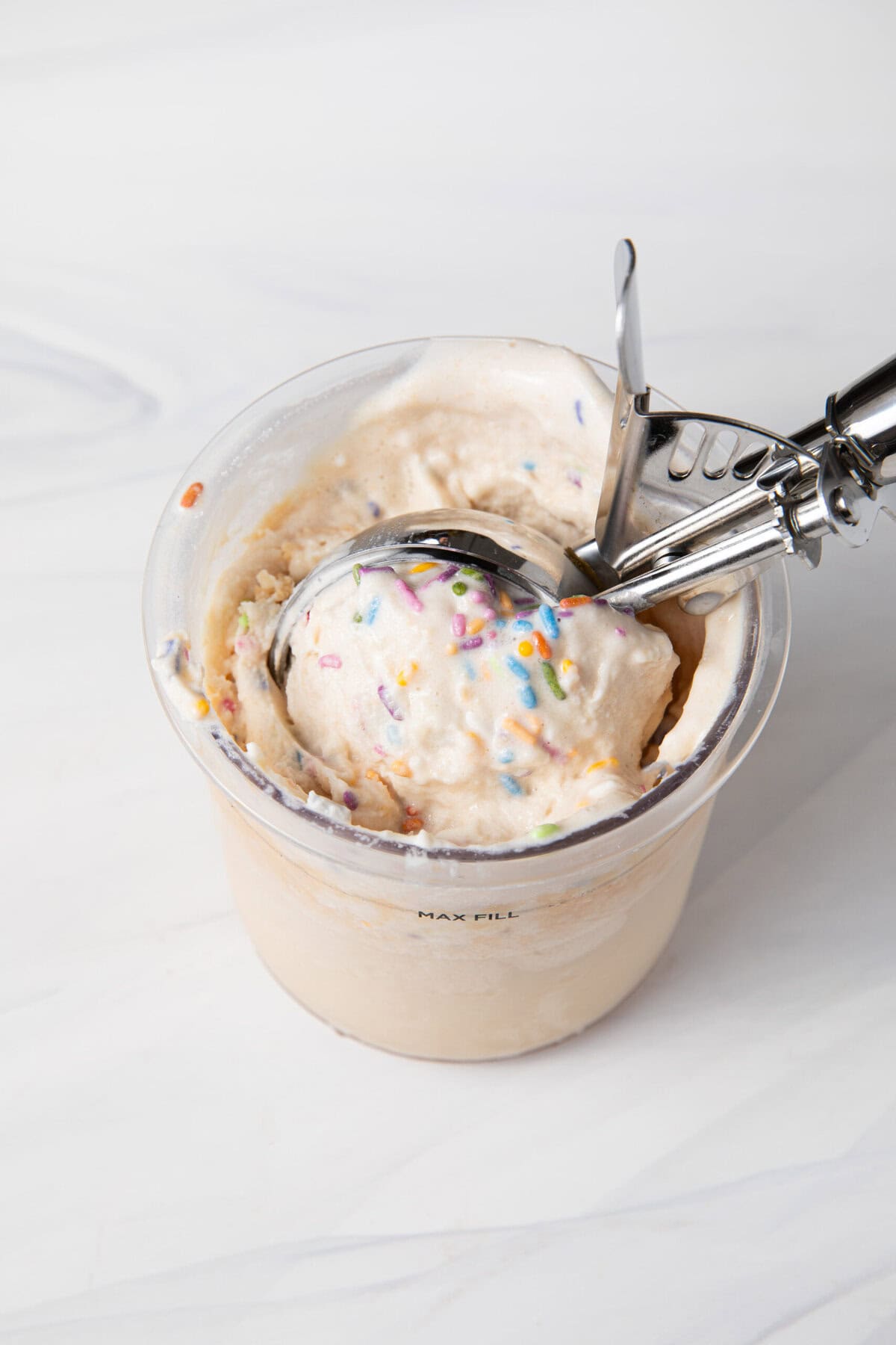 Birthday Cake Batter Protein Ninja Creami Ice Cream in the Ninja Creami pint being scooped.