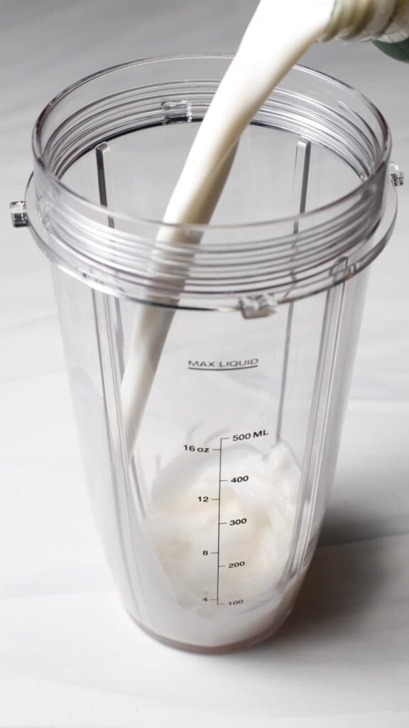 Pour the milks into the blender bottle for the Birthday Cake Batter Protein Ninja Creami Ice Cream base.