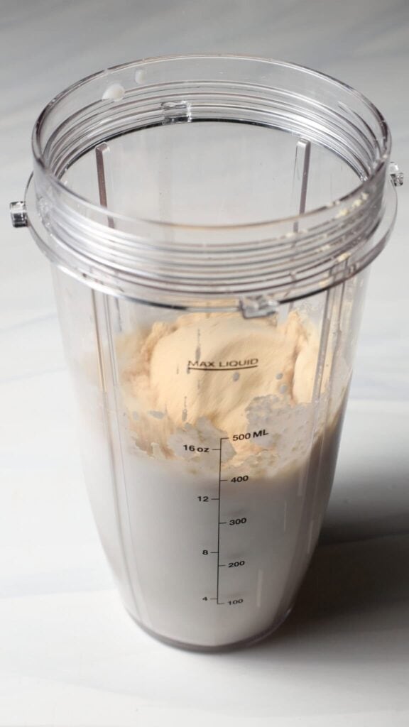 Pour the protein powder into the blender bottle for the Birthday Cake Batter Protein Ninja Creami Ice Cream base.