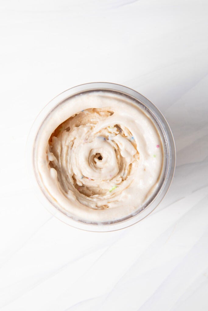 Birthday Cake Batter Protein Ninja Creami Ice Cream base in the Ninja Creami pint after mixing in the mix-ins.