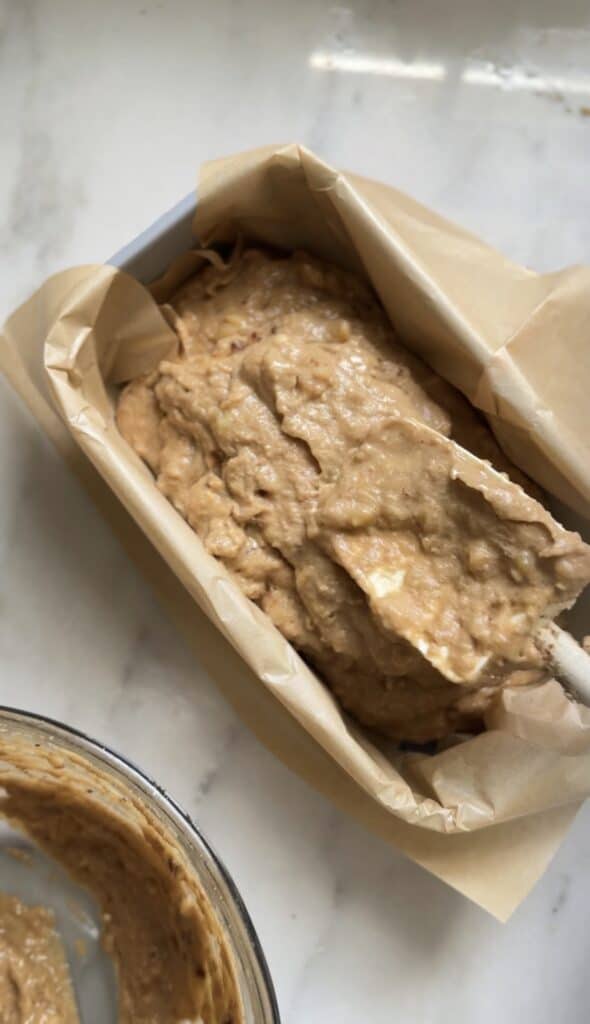 Pour the batter of the Gluten Free Protein Banana Nut Bread into a loaf pan.
