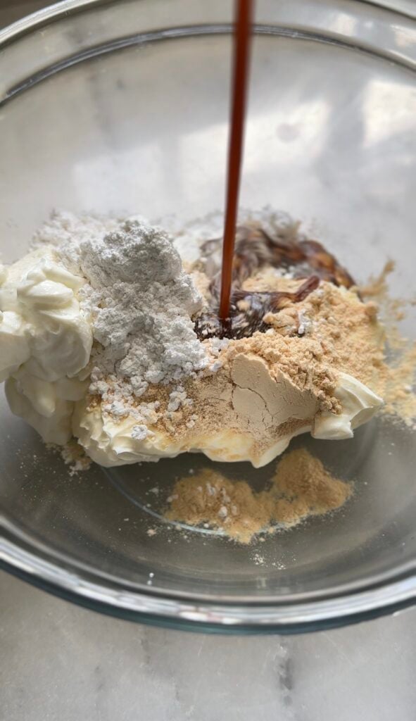 Adding the banana syrup to the frosting of the Gluten Free Protein Banana Nut Bread.