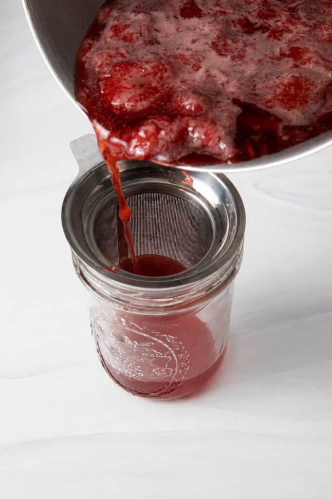 Strain the fresh Strawberry Simple Syrup through a fine mesh strainer.
