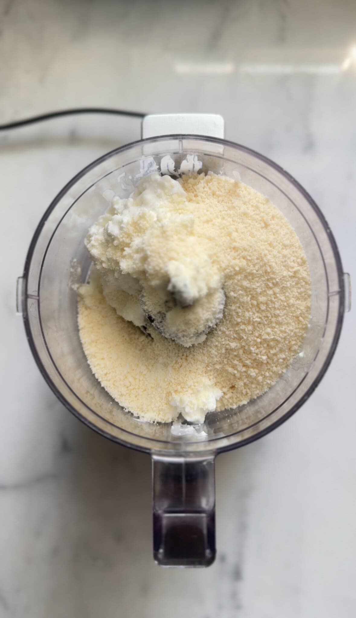 Part 1 of adding the cacio e pepe mac and cheese sauce ingredients in the food processor bowl.