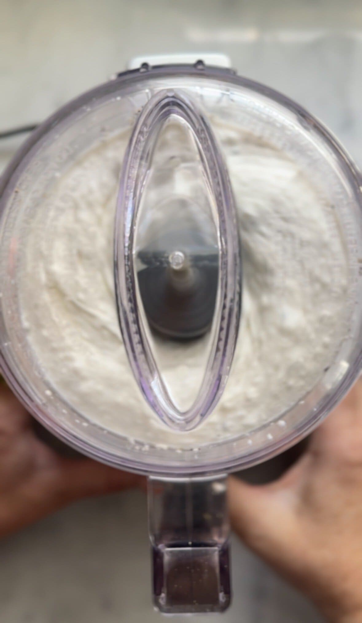 Blending cacio e pepe mac and cheese in a food processor bowl.